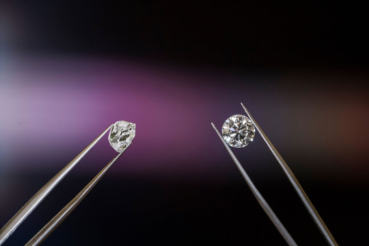 Two different diamonds being held up with jewelry tweezers showing CVD vs. HPHT vs. Mined Diamonds.