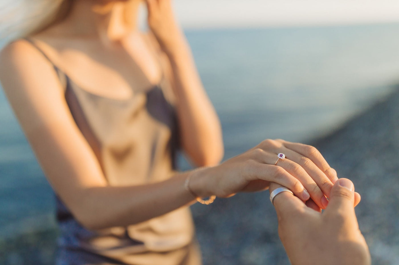 A couple during an engagement proposal on the beach, a great engagement idea.