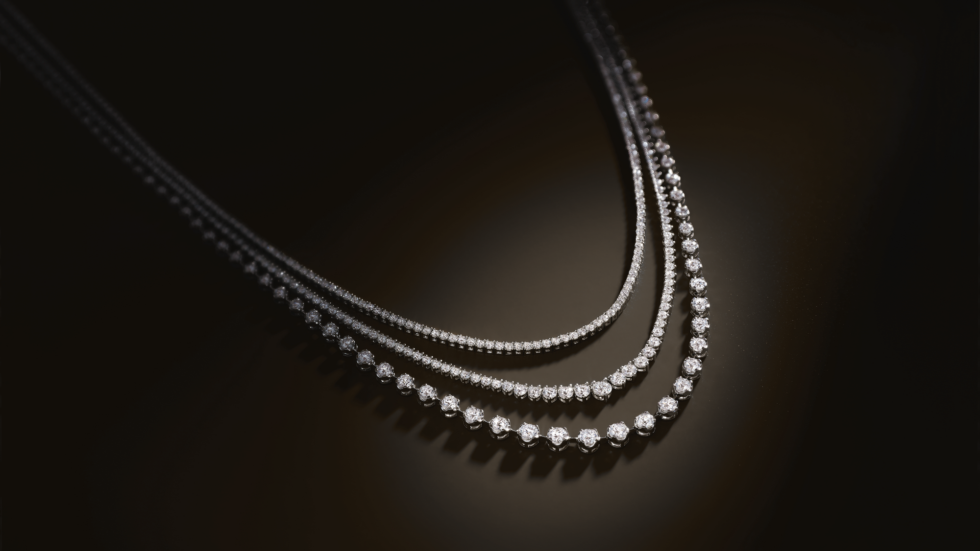 Close up of a flatlay 3 diamond tennis necklaces